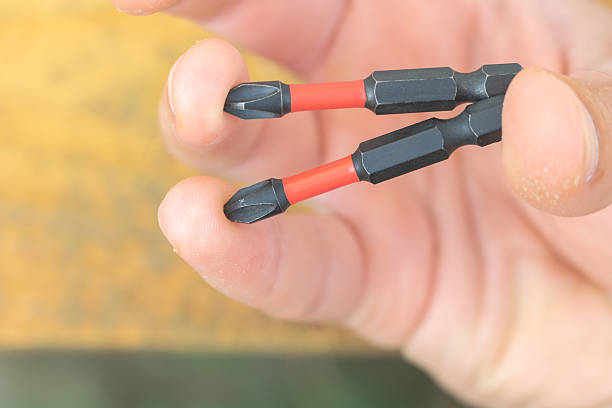 istock Close-Up of Hand Holding Two Magnetic Screwdriver Bits with Red Insulation 2227767541