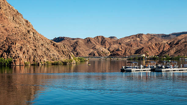 View of mountains reflecting on the tranquil waters of the Colorado River under clear skies in Arizona.