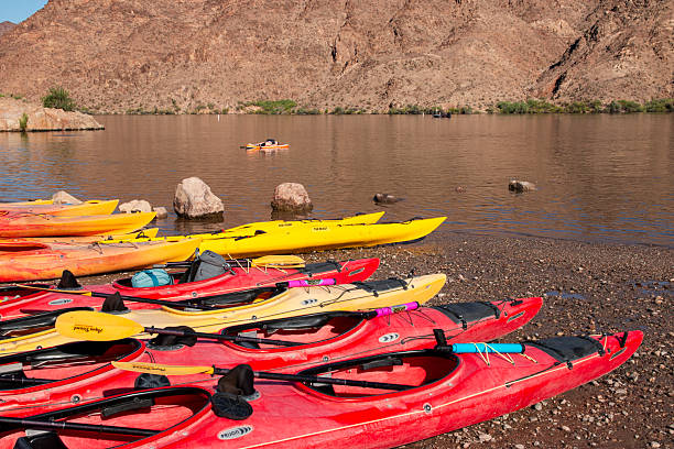 istock Bright Kayaks Lined up at Lakeshore Under a Clear Blue Sky 2227769889