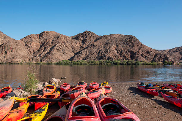 istock Explore Colorful Kayaks by the Calm River With Mountains in View 2227769897