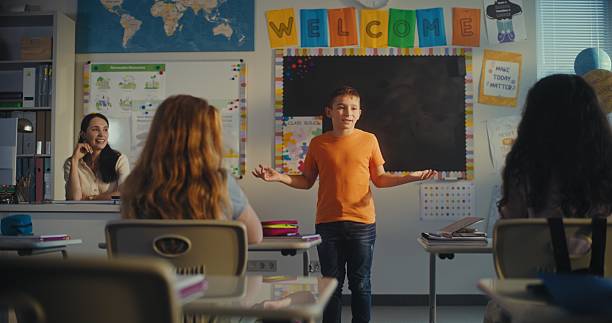 istock Female Teacher Calling Elementary School Student to the Board. Talented Boy Presenting Homework 2227775072