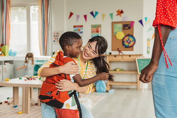 istock Preschool teacher in classroom greeting new student 2227776938