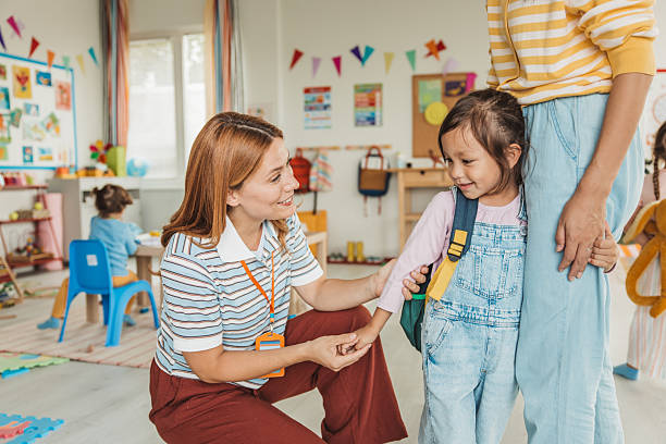 istock Preschool teacher in classroom greeting new student 2227776951