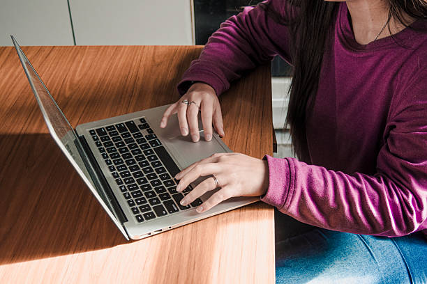 istock Young woman wearing a purple sweater using her computer for study at her desk. Remote work. 2227777874