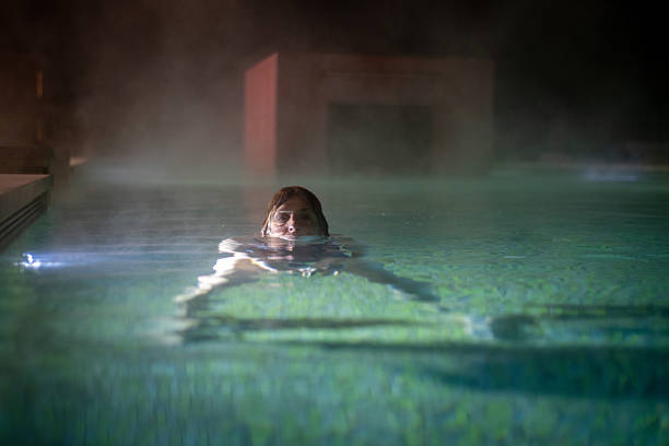Woman enjoying a thermal spa bath outdoors in the evening