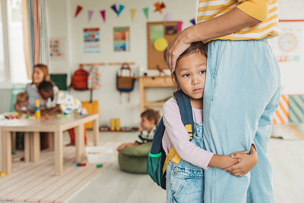 Preschool teacher in classroom greeting new student