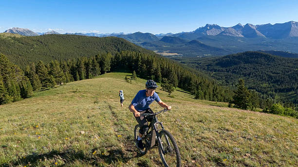 istock Mature man rides e-bike up mountain meadow 2227783440
