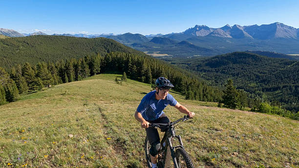 istock Mature man rides e-bike up mountain meadow 2227783449