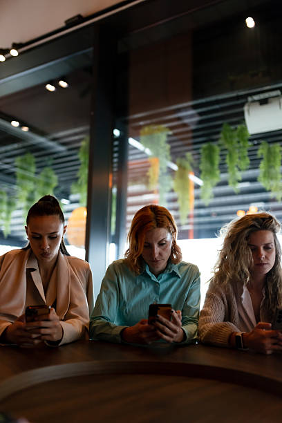 istock Businesswomen engaged in discussion and networking at a modern office space while using smartphones during a collaborative meeting 2227783766