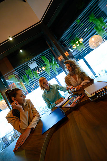 istock Three professionals collaborating at a modern office desk with natural decor. 2227783771