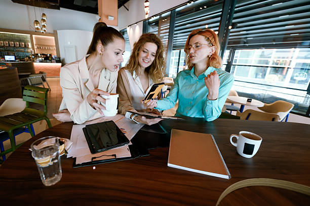 istock Businesswomen collaborating in a modern office setting while discussing ideas over coffee and documents in a casual atmosphere 2227783804