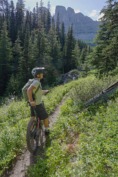 istock Young man pauses on pathway with electric mountain bike 2227783846
