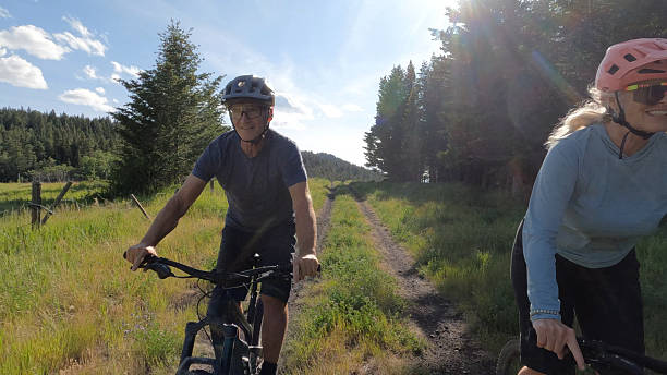 istock Front view of mature couple riding e-bicycles in forest 2227783970