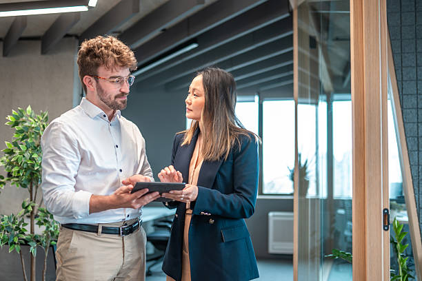 istock Young Hispanic Executive and Mature Asian Manager Reviewing Data on Tablet in Office 2227785514