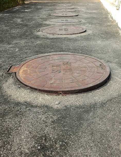istock Rusty Metal Round Manhole Cover on Concrete Road Surface 2227786570