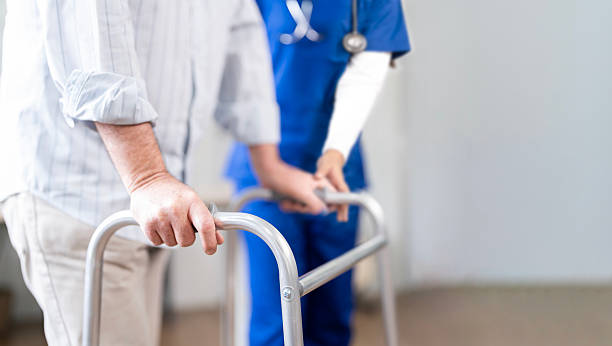 istock Cropped shot of young nurse helping old elderly disable man to walk using walker equipment at home 2227798007