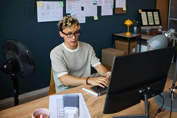 istock Young Adult Caucasian Man Working on Computer in Modern Office Environment 2227802982