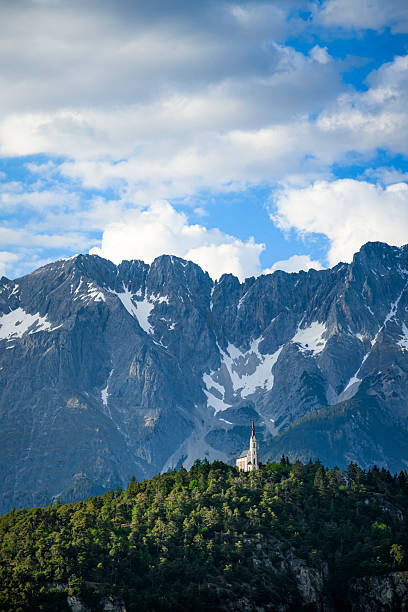 The church Maria Locherboden on a hill in Tyrol and the Austrian Alps in the background