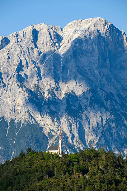 The church Maria Locherboden on a hill in Tyrol and the Austrian Alps in the background