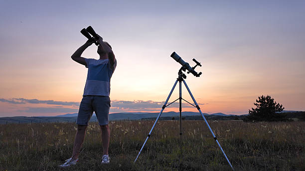istock Amateur astronomer using telescope and binoculars for watching stars, Moon, planets and other celestial objects from a countryside field in nature. 2227809334