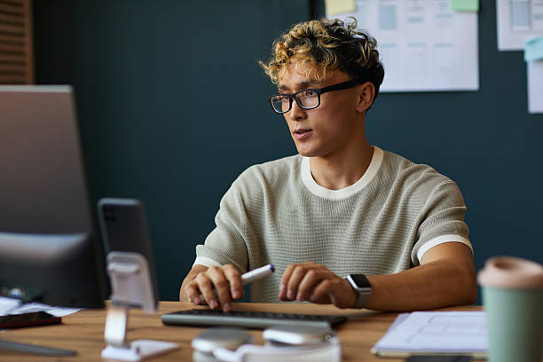 istock Young Adult Caucasian Man Working at Desk Using Computer in Modern Office 2227809763
