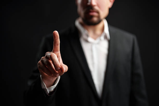 istock Businessman making a gesture while dressed in a suit against a dark background in a studio setting during a professional shoot 2227810224