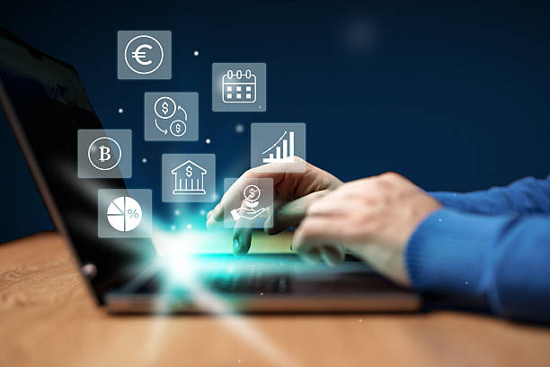istock Hands engaged in financial analysis on laptop with digital icons representing currency, graphs, and calendar 2227810628