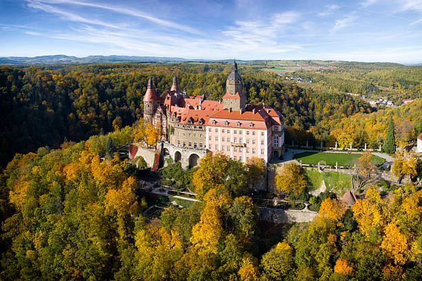 As the beautiful multi-colored foliage of the hill surrounds the castle, we admire the isolated look of the palace as it overlooks its beautiful town and blue twilight sky.