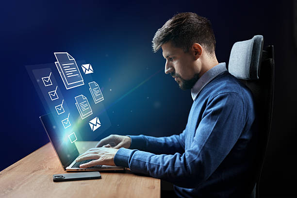 istock Professional man working on laptop with virtual documents and messages in a modern office setting at night 2227812709