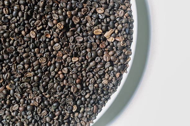 istock Green coffee beans in a white plate. Alternative drink concept. Selective focus. Horizontal orientation. Top view. Copy space 2227813447