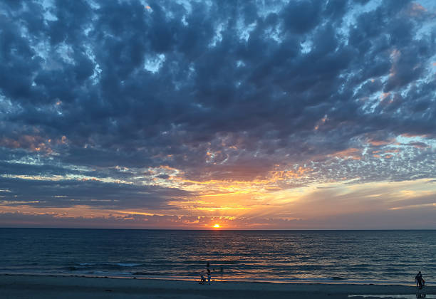 Dramatic ocean sunset with golden rays and glowing clouds, Australia