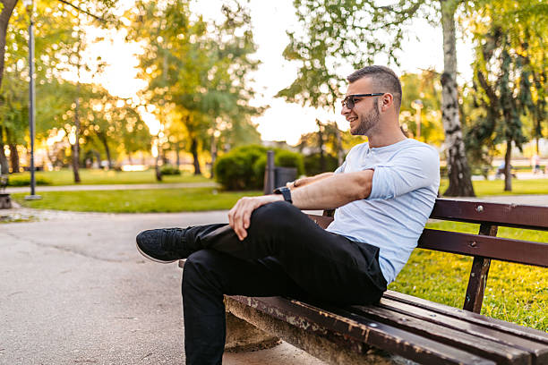 istock Young Man Sitting On A Park Bench 2227825134