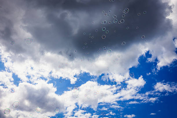 Giant soap bubbles float effortlessly against a vibrant blue sky