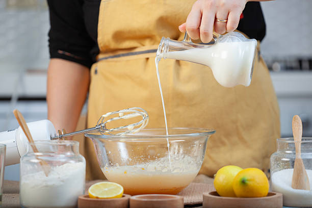 istock Woman adding milk to bowl. 2227826581