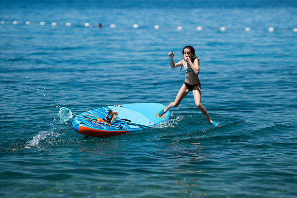 istock Girl jumping from paddleboard into clear blue water 2227826743