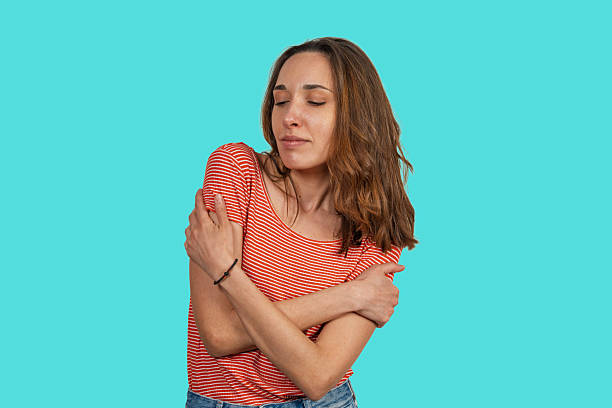 istock Young woman hugging herself on turquoise background 2227828232