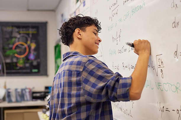 istock Teen student writing equation on whiteboard in classroom 2227831271