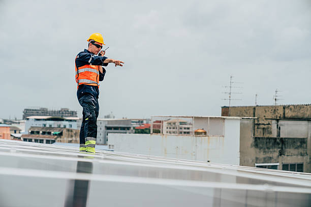 istock Construction worker directing activities on a rooftop in an urban setting during a cloudy day 2227832143