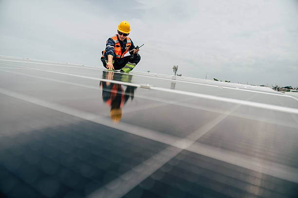 istock Technician inspects solar panels on rooftop in urban area during overcast day 2227832194