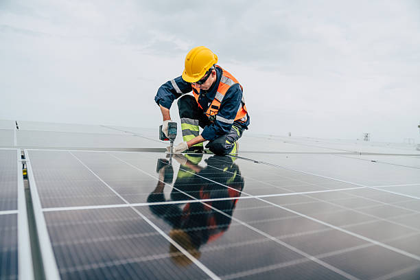 istock Technician installs solar panels on a rooftop during overcast weather while ensuring secure connections to optimize energy efficiency 2227832256