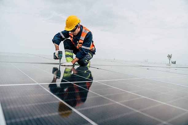 istock Solar panel technician installs photovoltaic system on rooftop during overcast day 2227832262