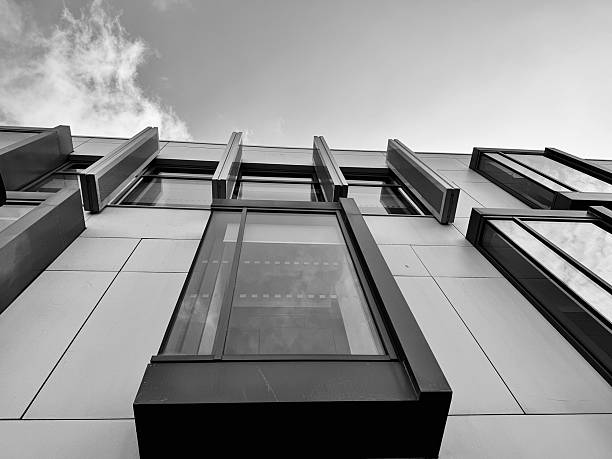 istock Looking up at modern urban architecture against cloudscape 2227833512