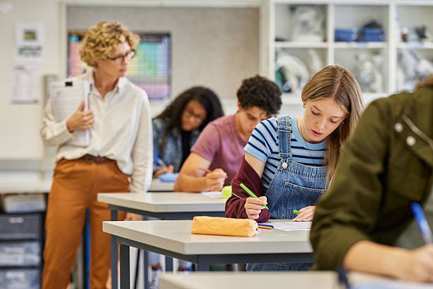 istock Female teacher observes students during exam at high school 2227835494