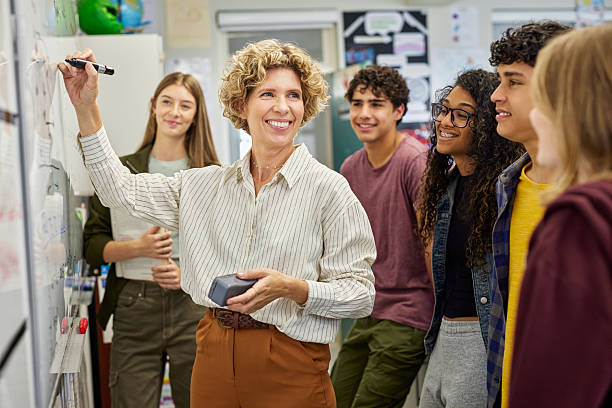 istock Smiling high school teacher teaching to class 2227836242