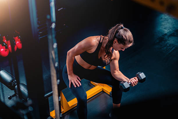 istock Biceps exercise with weights, a woman using weights for training to build strength in a  gym setting. 2227836889