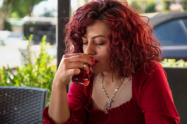 Young red-haired woman drinking tea in a cafe