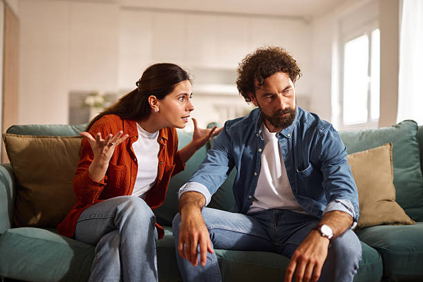 istock Frustrated couple arguing while sitting on sofa at home 2227846456
