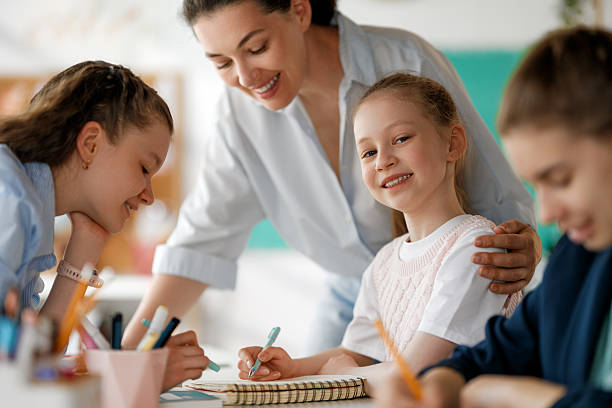 istock Happy kids and teacher at school 2227847633