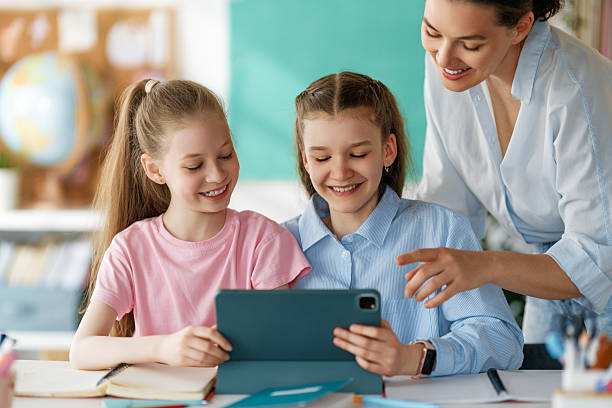 istock Happy kids and teacher at school 2227847721
