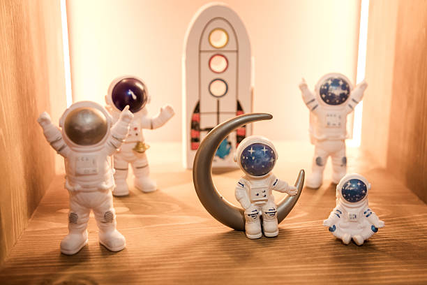 Astronaut figure on the shelf. Small white astronauts like kids toys.
